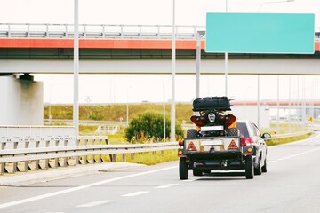 SUV towing ATV trailer on busy highway