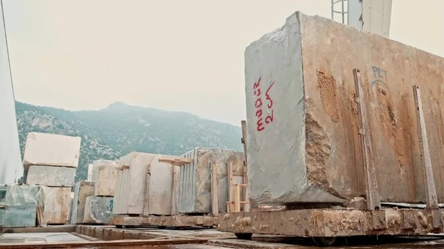 Marble quarry site with raw stone blocks. Various sizes and colors of stone blocks are stored as part of the production process.