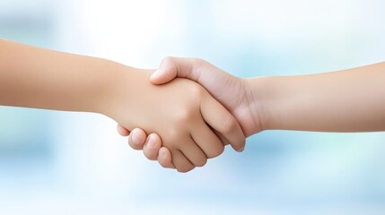 Two hands shaking in a business-like gesture, symbolizing agreement, partnership, or collaboration against a soft, blurred background.
