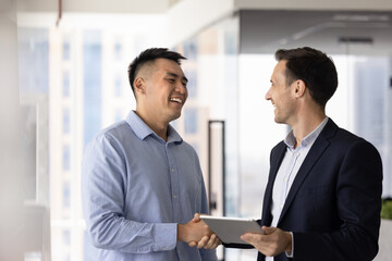 Cheerful Asian professional man shaking hands with legal expert, financial advisor, thanking for...