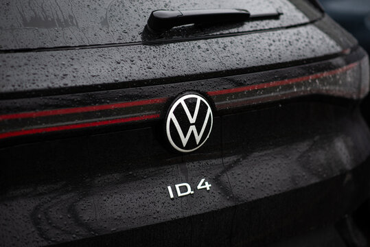 Kyiv, Ukraine - March, 2025. Close-up of a Volkswagen ID.4 rear badge on a wet black car with raindrops. Modern electric SUV in rainy weather.