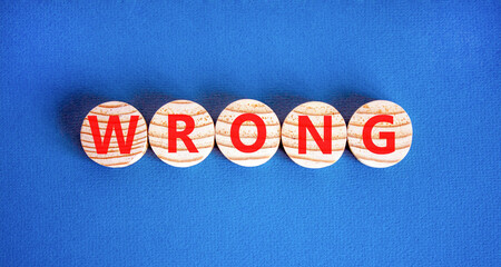 Wrong symbol. Concept word Wrong on beautiful wooden circles. Beautiful blue table blue background....