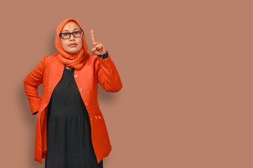 Confident Muslim Woman Pointing Up in Orange Blazer
