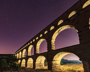Pont du Gard, ancient Roman aqueduct bridge, colorful projection mapping video show, under Provence starry night sky, Gorges du Gardon, natural landscape designated Biosphere Reserve by UNESCO, France