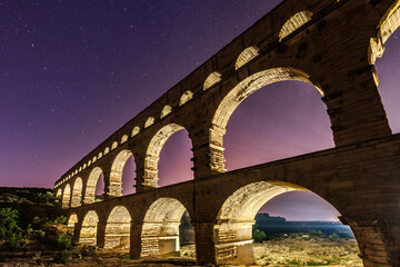 Pont du Gard, ancient Roman aqueduct bridge, colorful projection mapping video show, under Provence starry night sky, Gorges du Gardon, natural landscape designated Biosphere Reserve by UNESCO, France