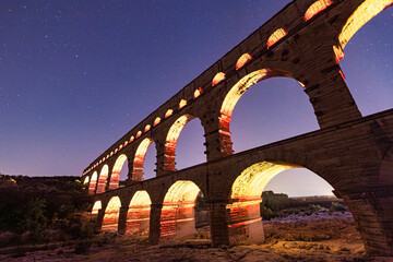 Pont du Gard, ancient Roman aqueduct bridge, colorful projection mapping video show, under Provence starry night sky, Gorges du Gardon, natural landscape designated Biosphere Reserve by UNESCO, France