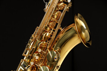 Obraz premium Jazz. One beautiful saxophone on black background, closeup