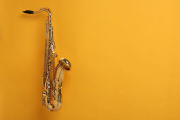 Golden saxophone on yellow background. Space for text