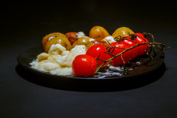 Roasted baby potatoes with creamy sauce and grilled cherry tomatoes