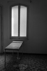 Una sala dell&rsquo;ospedale abbandonato del Lido di Venezia con una barella illuminata dalla luce che entra da una finestra