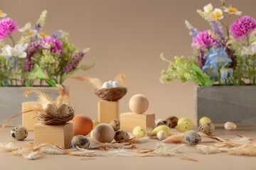 Easter composition with eggs, feathers, and spring flowers on a beige background.