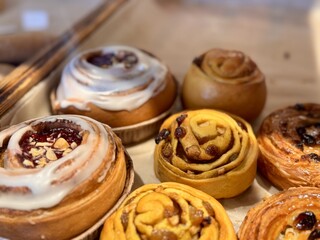 A Delicious and Tempting Assortment of Freshly Baked Sweet Rolls and Scrumptious Pastries. Enchanting display of freshly baked, golden sweet rolls with a variety of delightful fillings and toppings
