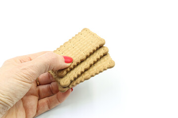 Woman's hand offering some cookies, on white background.