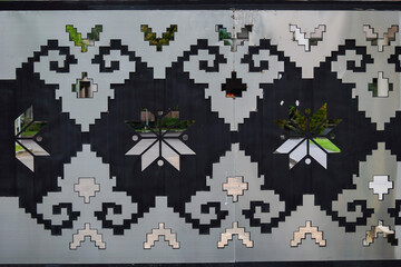 A black and white patterned wall with a silver border