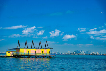 Naklejka premium Vibrant Waterfront Architecture: A colorful building with a unique design floats on the water.