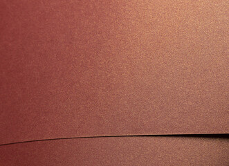 Burgundy paper background with a glossy, pearlescent texture and shimmering metallic finish. Rich,...