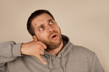 His relaxed demeanor suggests a fun and informal moment. The gesture conveys creativity and humor. The man positions his hand like a phone near his ear, pretending to make a call.