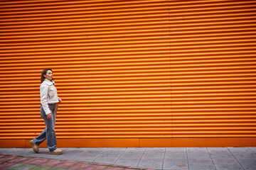 Woman walking on orange background