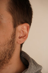 Obraz premium The image emphasizes simplicity and attention to detail. A minimalistic portrait highlighting the beauty of human anatomy. A close-up of a man s ear showcasing its natural lines and skin texture.