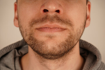 Obraz premium The unshaven look exudes effortless charm and simplicity. Perfect for themes of grooming and casual style. A detailed close-up of a man's chin with subtle stubble, showcasing masculine appeal.