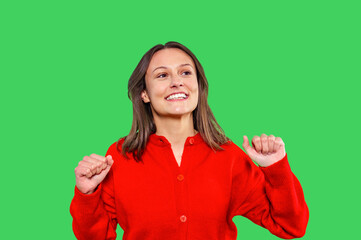 Cheerful woman celebrating joyfully in vibrant red sweater against  bright green background