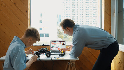 Teacher help student fixing car model and giving advise for programing system or coding prompt...