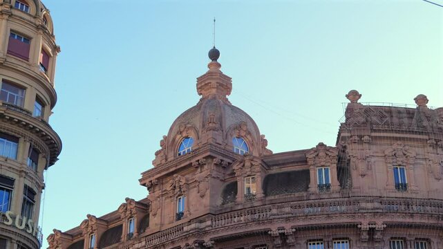 Close-up of the historic Banca Carige building in Genoa&rsquo;s Piazza De Ferrari, showcasing its architectural dome, sculptures and detailed stone facade in evening light