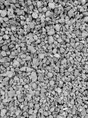 Crushed metallurgical slag. Fine fraction. Porous structure. Production waste. Recycling, reuse. Use for road construction. Gray background. Black and white photo. Copy space for text.
