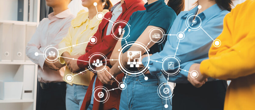 A diverse group of professionals in a modern office setting demonstrates teamwork and collaboration, with digital icons representing various management concepts and innovative ideas. Amity