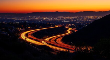 Winding highway at sunset over city lights