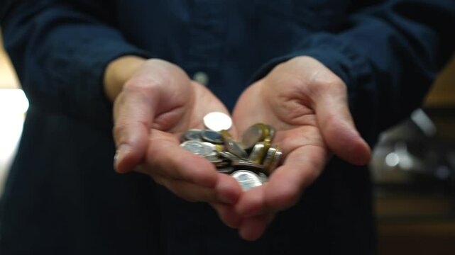 Coins in a man's palms.
Close-up of cash in hands.
Metal coins