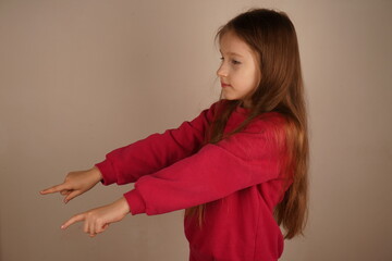 The light background highlights her striking features. A young red-haired girl, dressed in a red...