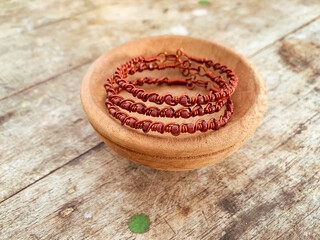 handmade wire copper bracelet on wooden table