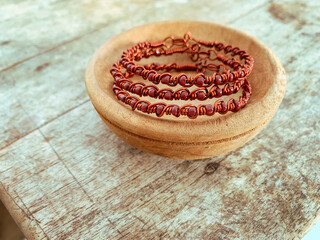 handmade wire copper bracelet on wooden table