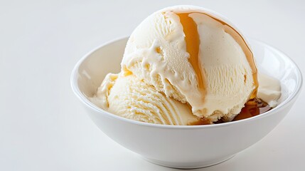 A perfectly round scoop of vanilla ice cream served with caramel sauce lightly drizzled over it
