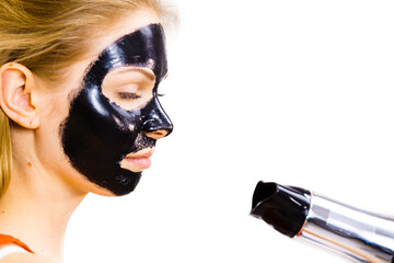 Girl drying peel-off black mask on face