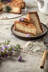 Slice of homemade cottage cheese cheesecake on linen napkin with spring flowers. Healthy organic dessert pie cheesecake