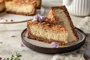 Slice of homemade cottage cheese cheesecake on linen napkin with spring flowers. Healthy organic dessert pie cheesecake