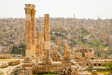 Roman ruined temple columns and many residential houses densily scattered on the hills in the downtown of Amman city, Kingdom of Jordan