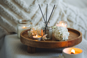 Burning candles, aroma fragrance natural organic diffuser, wooden bamboo tray. Concept of cozy home space for meditation, relaxation. Spiritual aura cleansing routine. Spring hyacinth blossom scent