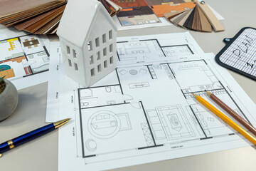 On the table, there is a detailed floor plan of a house showcasing its layout and design