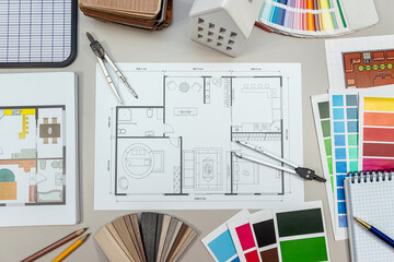 On the table, there is a detailed floor plan of a house showcasing its layout and design