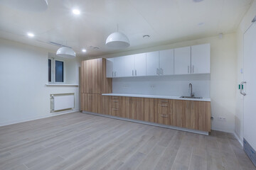 A spacious room in an office facility with an installed kitchen set for lunch breaks.