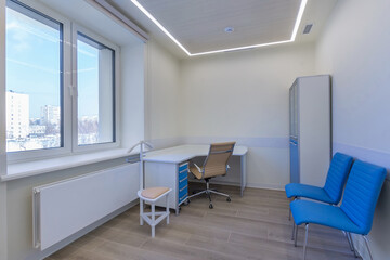 A modern doctor's office in an outpatient medical facility with furniture and a window with a winter landscape.