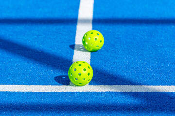 two pickleball ball in a blue court, new racket sport concept background