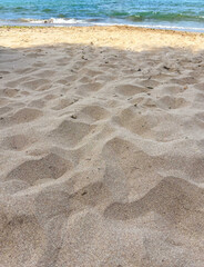 Detailed view of sandy beach texture showcasing fine grain patterns and natural colors