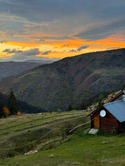 Forest house and view of mountains, red sunset sky