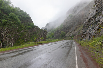 Kapan-Kajaran highway in Syunik, Armenia, passing through a misty mountain landscape. The famous Bear statue symbolizes the treasures of Kajaran, home to a major copper and molybdenum open-pit mine