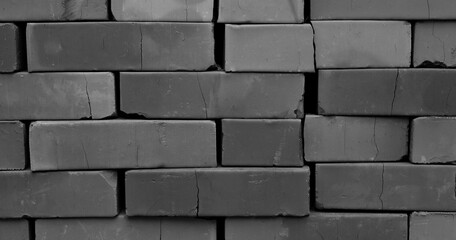Obraz premium Cracks run through stacked bricks black and white photo for backgrounds. Traditional construction materials stock image 