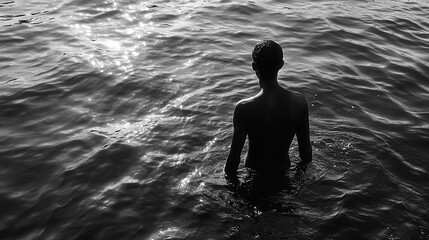 Fototapeta premium Person wading in water serene water reflection black and white photography calm environment side view contemplation